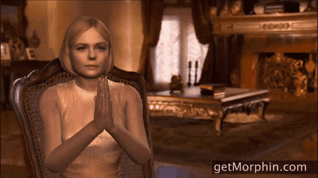 a woman sits in a chair with her hands folded in front of a fireplace with the website getmorphin.com below her
