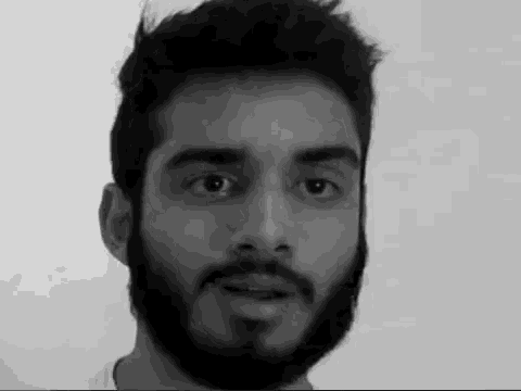 a man with a beard is talking in a black and white photo .