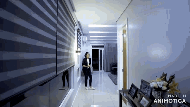 a woman standing in a hallway with the words made in animotica on the bottom right