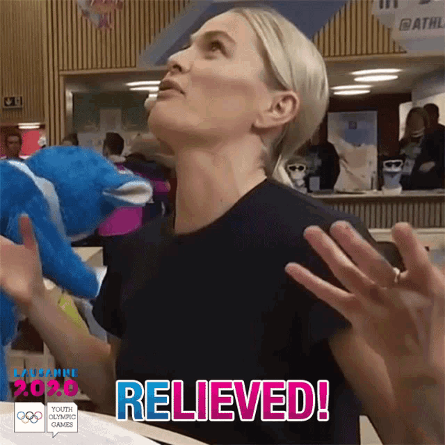 a woman in a black shirt is holding a stuffed animal and the word relieved is on the bottom right