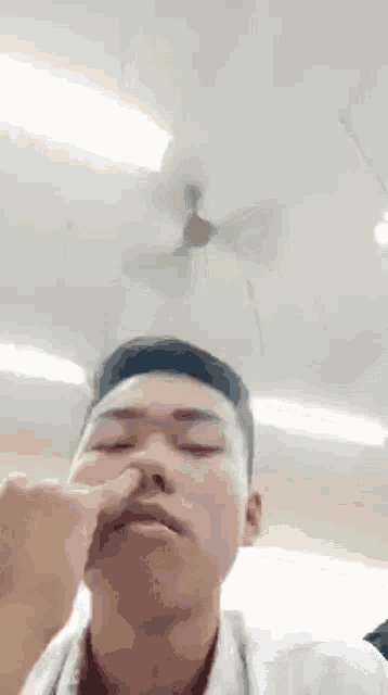 a man is making a funny face while holding his nose .