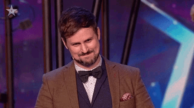 a man in a suit and bow tie is pointing up