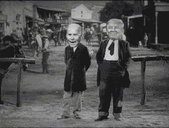 two men with masks on their faces are standing next to each other on a dirt road