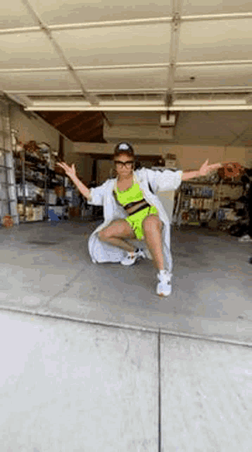 a woman in a neon outfit is squatting in a garage
