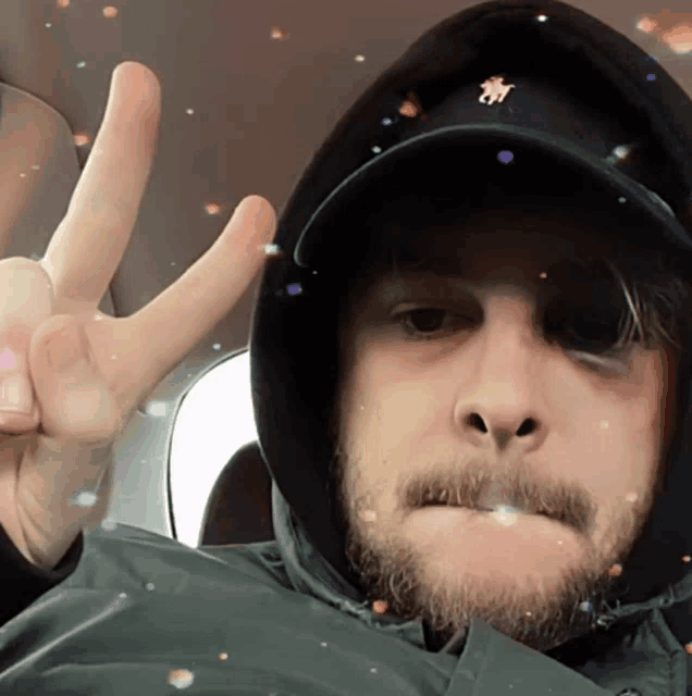 a man wearing a hooded jacket and a hat with the letter h on it
