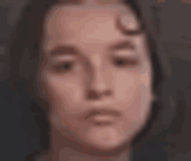a close up of a woman 's face with her eyes closed and a blurred background .