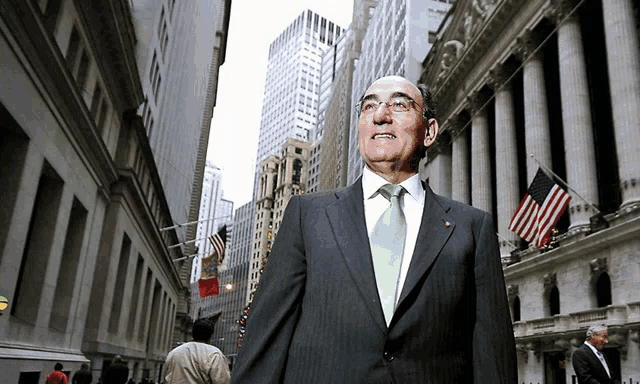 a man in a suit stands in front of a building