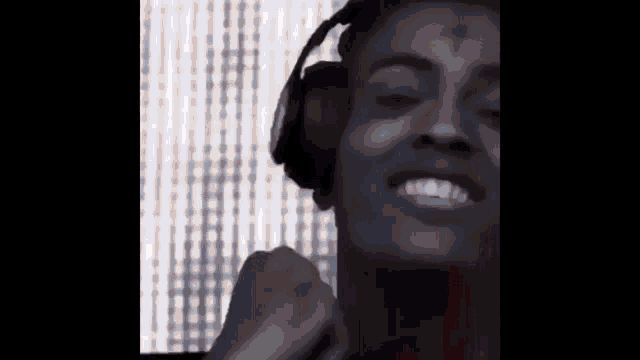 a close up of a man wearing headphones and smiling .