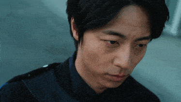 a close up of a man 's face with his eyes looking down