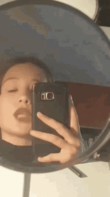 a woman is taking a selfie in a mirror with her cell phone