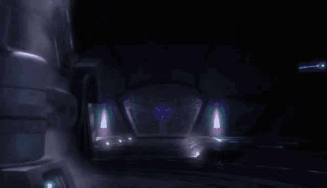 a man in a helmet is standing in a dark room with a purple light behind him