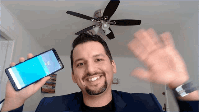a man in a suit holds up a cell phone that says lg