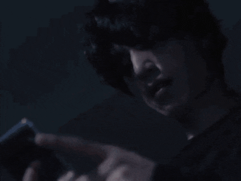 a close up of a person using a cell phone in the dark .