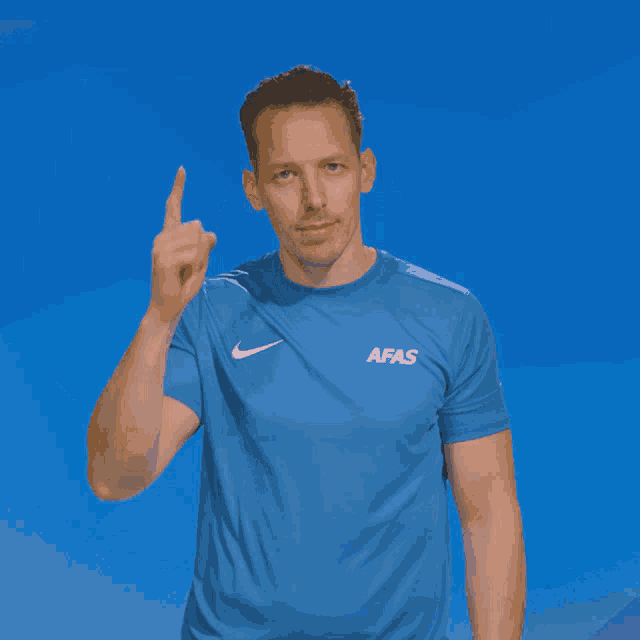 a man wearing a blue shirt with afas on the front