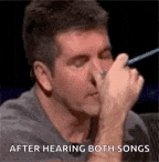 a man is covering his nose with his hand while listening to music .