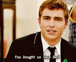 a man in a suit and tie is talking about taco bell