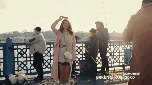 a woman in a pink coat is taking a picture of a man