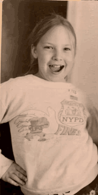 a young girl is wearing a nypd fires sweatshirt