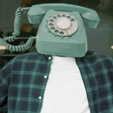 a man wearing a green plaid shirt has a telephone on his head