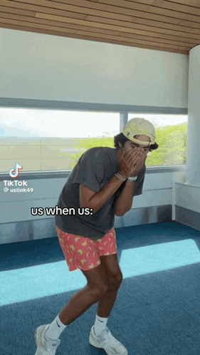a man covering his face with his hands while a tiktok video says " us when us " on the bottom