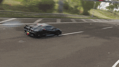 a gray and black sports car is driving on a street