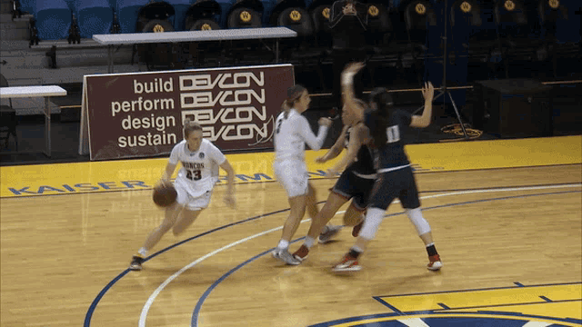 a basketball game is underway with a sign that says build perform design sustain