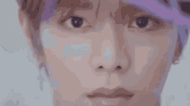 a close up of a person 's face wearing a purple hat .
