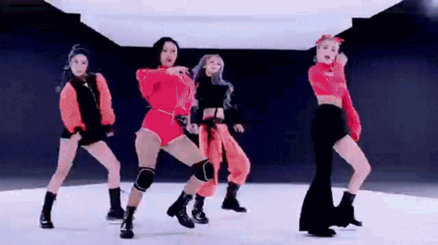 a group of women are dancing on a stage in a room .