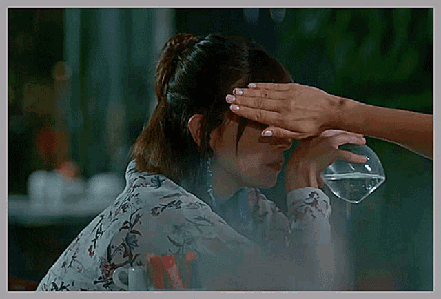 a woman sitting at a table with a glass of water