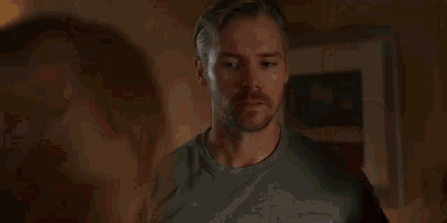 a man and a woman are standing in a hallway talking to each other .