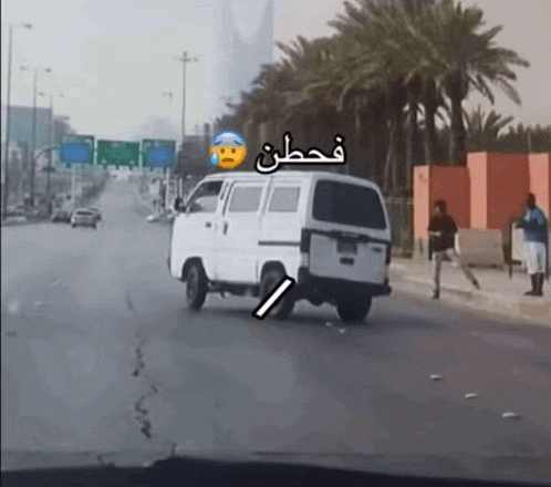 a white van is parked on the side of the road with arabic writing on it