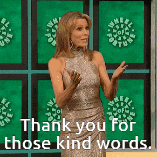 a woman in a silver dress stands in front of a wheel of fortune logo and says thank you for those kind words