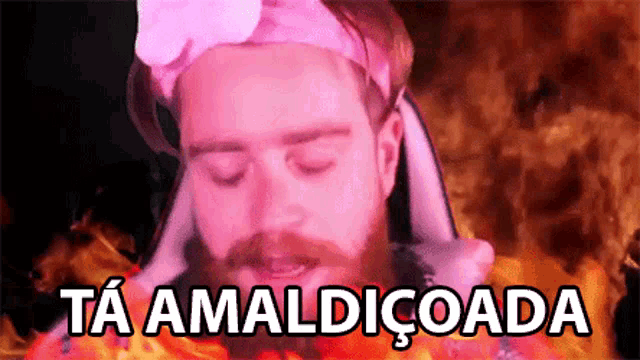 a man with a beard is wearing a pink headband and says ta amaldicoada