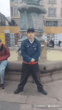 a man stands in front of a fountain wearing a hat with the letter n on it