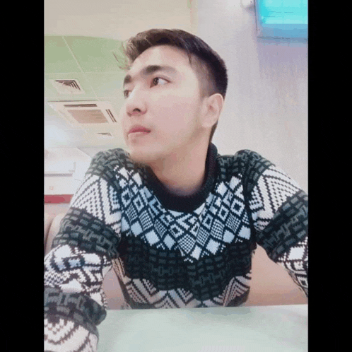 a man wearing a black and white sweater with a pattern on it