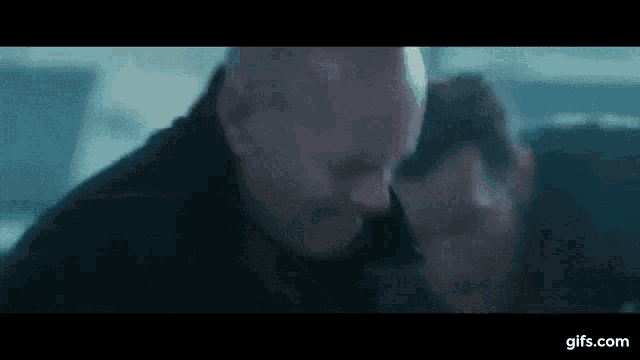 a man with a mustache is holding another man 's head .