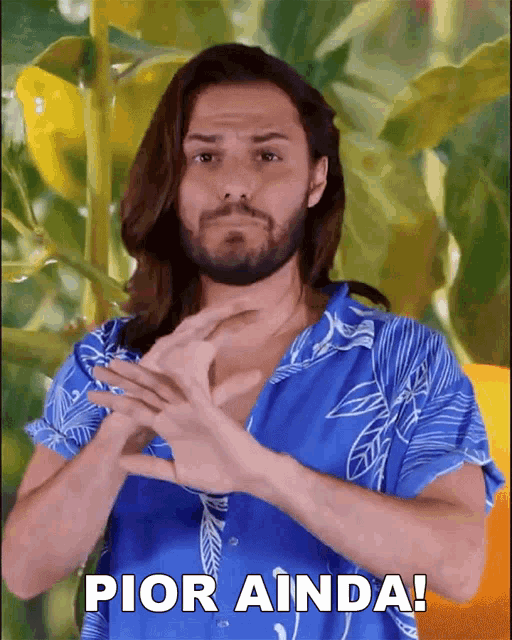 a man with long hair and a beard wearing a blue shirt says pior ainda