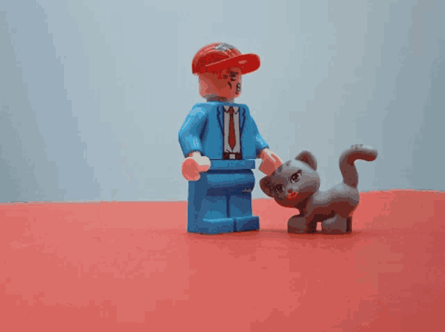 a group of toy cats are standing around a toy man