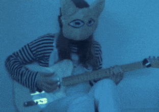 a person wearing a cat mask is playing a guitar with the words " another year " below them