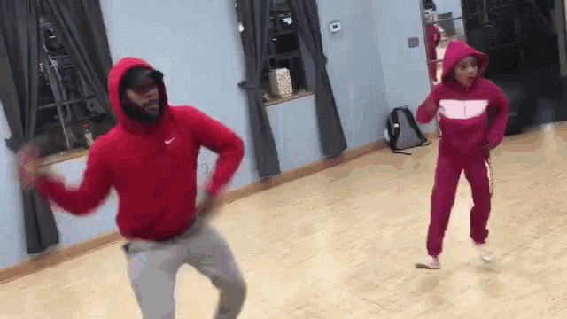 a man and woman are dancing in a dance studio