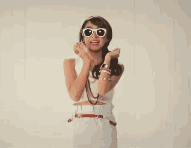 a woman wearing white sunglasses and a red ring