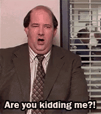 a bald man in a suit and tie is talking to someone .