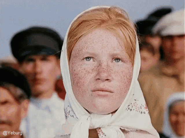 a woman with red hair and freckles wearing a white scarf around her head
