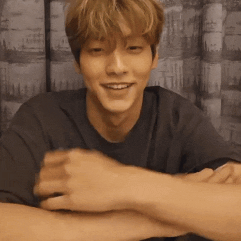 a man with his arms crossed is smiling and looking at the camera