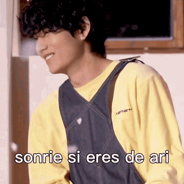 a man wearing overalls and a yellow shirt is smiling with the words sonrie si eres de ari written below him