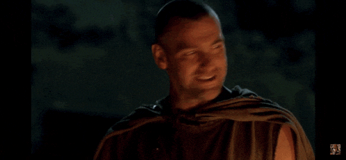 a man in a cape is smiling in a dark room with a fox logo in the corner