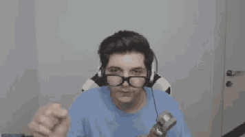 a man wearing glasses and headphones is sitting in a chair holding a hammer .