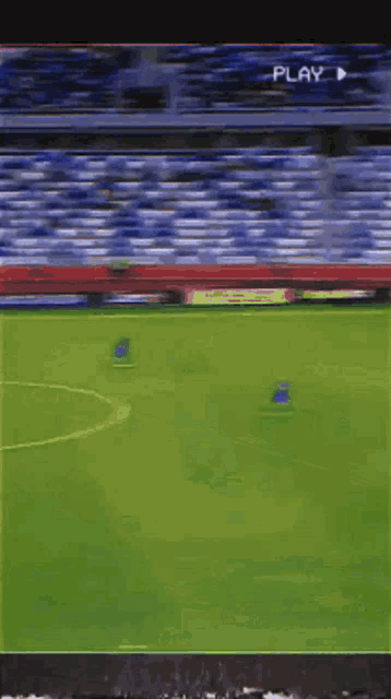 a soccer game is being played in a stadium and the play button is visible
