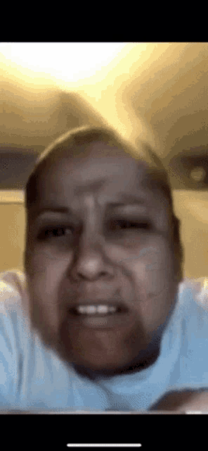 a woman in a white shirt is making a funny face while looking at the camera .