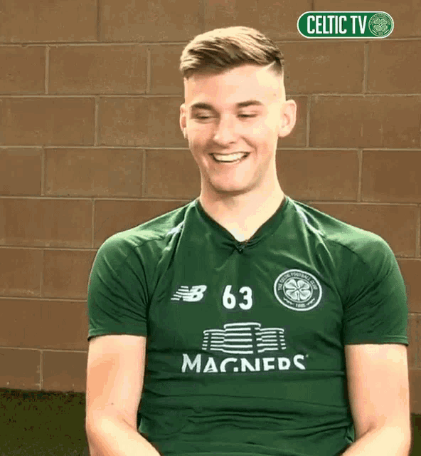 a man wearing a green shirt that says magners on it